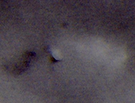 Black & White near infrared photo of triangular ufo emitting a cloud like material. Notice the shadow it is casting on the cloud layer behind it.