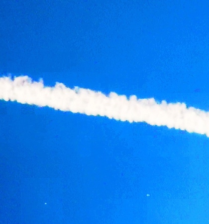 Enhanced still from video footage of orb shaped objects traveling in and around chemtrail spray.